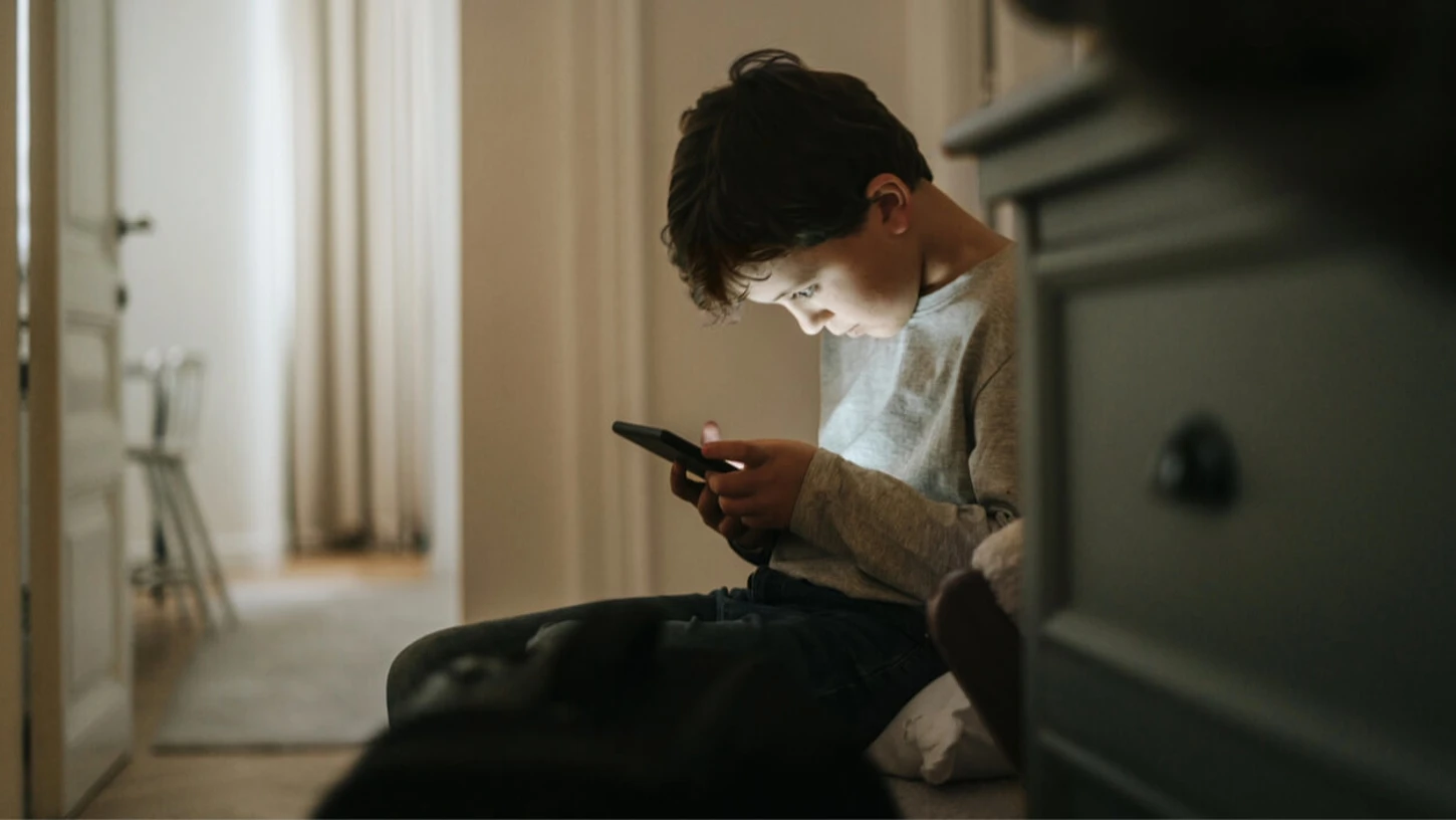 Deček na mobilnem telefonu.